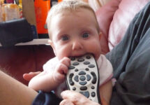 baby chewing on remote control