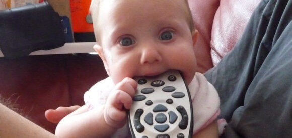 baby chewing on remote control